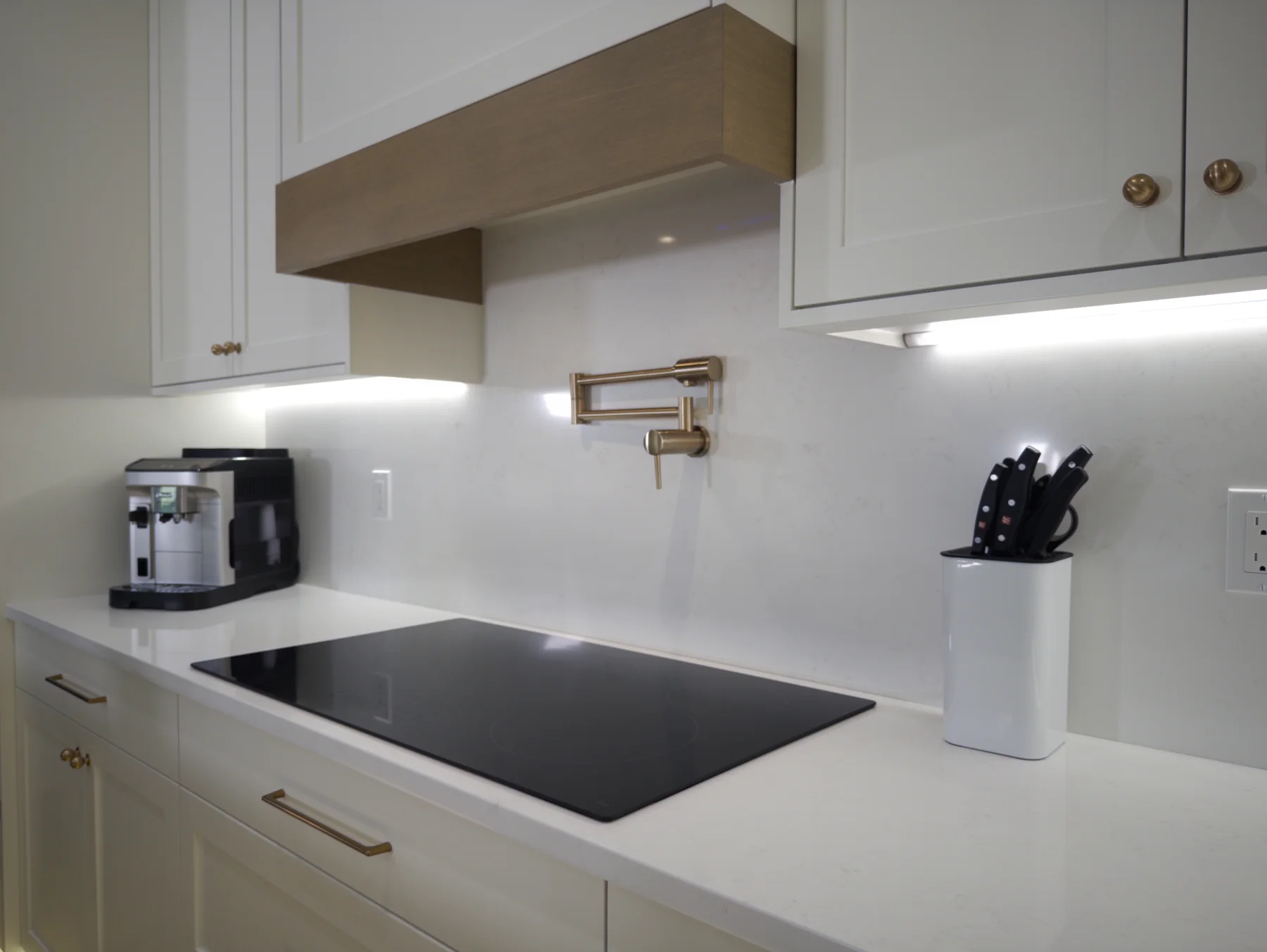 Quartz cooktop cutout and matching full-height backsplash below the range hood