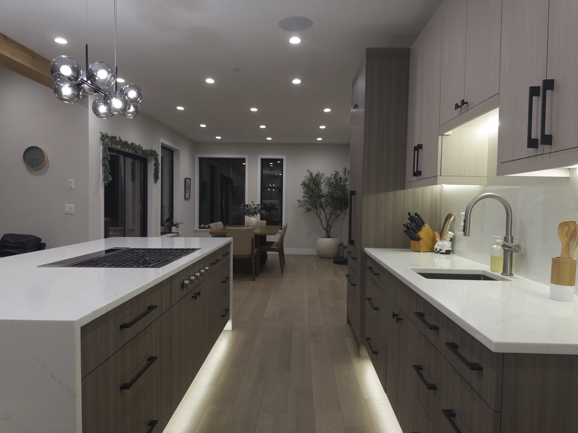 Waterfall quartz island with a cooktop and matching perimeter countertop in the main kitchen