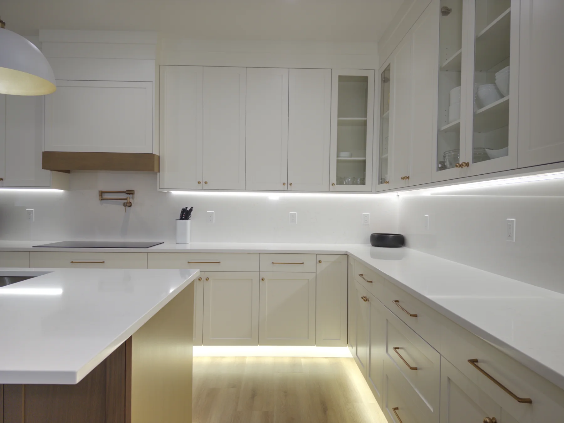 Opulent quartz perimeter countertops and full-height backsplash beneath white cabinets
