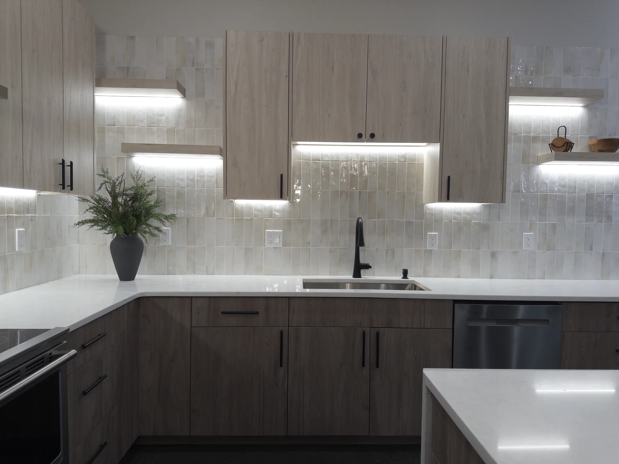 Quartz countertop with an undermount sink and tile backsplash in the secondary kitchen
